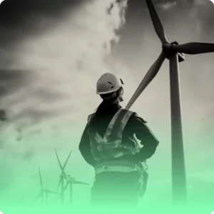 a person looks up at a wind turbine